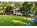 Beautiful home with lush front yard, blue hydrangeas, and a cozy screened-in porch at 1744 Blossom Ln, Austell, GA 30168
