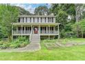 Charming two-story home with a welcoming front porch, garden beds, and a well-manicured lawn at 2816 Highland Park Dr, Stone Mountain, GA 30087