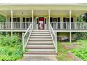 Inviting front porch with white railings, steps leading up to the entrance, and charming outdoor lighting at 2816 Highland Park Dr, Stone Mountain, GA 30087