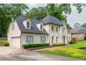 Side view of this two-story home shows brick, siding, driveway, manicured lawn and tidy landscape at 2735 Jims Ne Rd, Marietta, GA 30066
