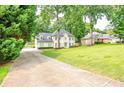 Long driveway leading to a beautiful two-story home with white brick, shutters, and well-manicured front yard at 2735 Jims Ne Rd, Marietta, GA 30066