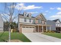 Two-story home featuring a brick and siding facade, dormer windows, and an attached two-car garage at 313 Foxglove Way, Mcdonough, GA 30253