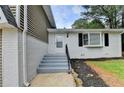 Inviting front entrance with gray painted steps and brickwork with a well maintained lawn at 1094 Amber Sw Rdg, Lilburn, GA 30047
