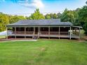 Inviting home featuring a full, covered porch with wooden railings, complemented by a lush green lawn at 360 Parr Farm Rd, Covington, GA 30016