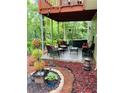 Relaxing covered patio features comfortable seating, a hot tub, and a tranquil garden area at 7052 Camp Falls Ct, Winston, GA 30187