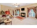 Elegant living room featuring a fireplace, plush carpeting, and ornate decor with large windows and classic furniture at 7052 Camp Falls Ct, Winston, GA 30187