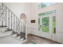 Bright foyer with decorative glass front door, staircase with iron railing, and wood-look flooring at 1039 Avery Creek Dr, Woodstock, GA 30188