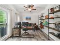 Comfortable home office featuring wood-look flooring, built-in shelves, and a backyard view at 1039 Avery Creek Dr, Woodstock, GA 30188