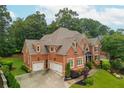 Aerial view of a brick two-story home showcasing its roof and well-manicured lawn and driveway at 2688 Hidden Falls Ne Dr, Buford, GA 30519