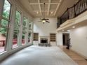 Spacious living room with built-in bookshelves, large windows and stone fireplace at 2688 Hidden Falls Ne Dr, Buford, GA 30519