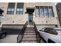 Inviting townhome entry with brick staircase leading to a covered doorway and private garage at 3208 Sonnet Se Walk, Atlanta, GA 30339