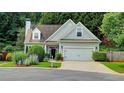 Traditional home with neutral siding, attached garage, green lawn and tree lined property at 3954 Rhyne Se Way, Smyrna, GA 30082