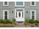 Elegant front entrance featuring a decorative white door flanked by sidelights and lush landscaping at 5223 Willow Ridge Dr, Woodstock, GA 30188