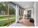 Inviting screened porch with tile flooring, neutral decor, and views of the serene landscaped yard at 879 Wildwood Ne Rd, Atlanta, GA 30324