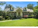 Traditional brick home featuring a lush front lawn, dormer windows, and manicured landscaping at 1821 N Rock Springs Ne Rd, Atlanta, GA 30324