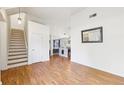 Open floor plan with hardwood floors, staircase, and view into the kitchen at 7033 Brecken Trce, Lithonia, GA 30058