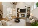 Bright living room featuring vaulted ceilings, built-in bookshelves, and a cozy fireplace at 8010 Majors Mill Dr, Cumming, GA 30041