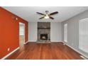 Living room featuring wood floors, stone fireplace, modern ceiling fan, and natural light at 133 Harold Dr, Mcdonough, GA 30253