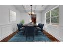Bright dining room with wainscoting, coffered ceilings, chandelier, and hardwood floors at 7601 Watson Cir, Locust Grove, GA 30248