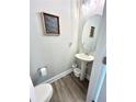 Cozy half bathroom with a pedestal sink, oval mirror, and modern wood-look flooring at , Covington, GA 30014