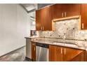 Kitchen with stainless steel dishwasher, granite countertops, and wooden cabinetry at 943 Peachtree Ne St # 2001, Atlanta, GA 30309