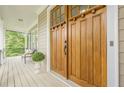 Inviting front porch with double wood front doors, a seating area, and charming accents at 3440 Canyon Oak Way, Cumming, GA 30041