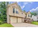 Side view of the home showcasing the two-car garage and inviting entrance at 1214 Tyne Way, Stone Mountain, GA 30088
