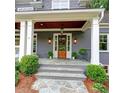 Classic front entry featuring a wood door flanked by wall sconces and a stone walkway at 1178 Chambord Ne Way, Brookhaven, GA 30319