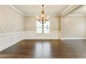 Elegant dining room with hardwood floors, decorative molding, and a stylish chandelier creating a warm atmosphere at 3821 Chamblee Dunwoody Rd, Atlanta, GA 30341