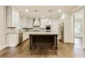 Modern kitchen featuring white cabinetry, stainless steel appliances, granite countertops, and a central island at 3821 Chamblee Dunwoody Rd, Atlanta, GA 30341