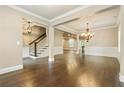 Spacious living area featuring hardwood floors, elegant lighting, and open access to other parts of the home at 3821 Chamblee Dunwoody Rd, Atlanta, GA 30341