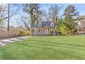 Beautiful house with a large, well-manicured front lawn, trees, and a long driveway leading to the side of the house at 1824 Westwood Sw Ave, Atlanta, GA 30310