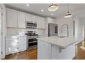 Modern kitchen featuring white cabinets, stainless steel appliances, a subway tile backsplash, and a center island at 1824 Westwood Sw Ave, Atlanta, GA 30310