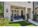 Inviting covered patio with stylish seating, lush plants, and ceiling fan for comfortable outdoor relaxation at 408 Townly Ct, Alpharetta, GA 30009