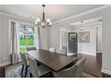Elegant dining room with hardwood floors, modern lighting fixture, and a view of the well-manicured lawn at 147 Longleaf Dr, Canton, GA 30114
