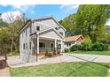 Side view of a modern gray home with white trim, a front porch, and a driveway leading to the house at 1521 Sylvan Sw Rd, Atlanta, GA 30310