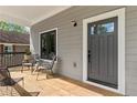 Inviting front porch featuring wood decking, stylish seating, and a modern front door with a window at 1521 Sylvan Sw Rd, Atlanta, GA 30310