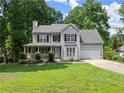 Charming two-story home with a covered porch and a well-manicured lawn and two-car garage at 5510 Pilgrim Point Ext, Cumming, GA 30041
