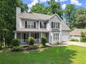 Charming two-story home with a covered porch and a well-manicured lawn and two-car garage at 5510 Pilgrim Point Ext, Cumming, GA 30041