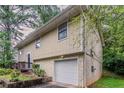Side view of a charming home with a garage, landscaped yard, and a well-kept lawn at 2139 Jonathan Ave, Lithonia, GA 30058