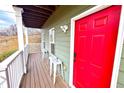 Welcoming front porch with a vibrant red door and seating for relaxing at 2650 Batavia St, East Point, GA 30344