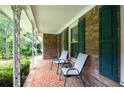 Inviting porch with brick flooring, seating, and green shutters, perfect for relaxation at 695 Hiram Sudie Rd, Dallas, GA 30157