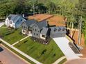 Stunning new construction home with manicured lawn, lush landscaping, and three-car garage at 115 Nova Lane, Roswell, GA 30075