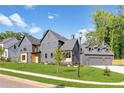 Contemporary home with gray exterior, a two-car garage, and manicured landscaping at 115 Nova Lane, Roswell, GA 30075