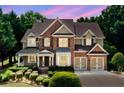 Charming two-story brick home featuring manicured landscaping and a two-car garage at 1415 Liberty Ln, Cumming, GA 30040
