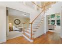 Bright foyer featuring hardwood floors, staircase with white railings and open access to other rooms at 1415 Liberty Ln, Cumming, GA 30040