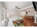 Open floor plan with hardwood floors and gray sectional sofa, with access to dining area at 1735 Peachtree Ne St # 117, Atlanta, GA 30309