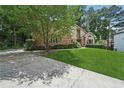 Beautiful home featuring a well-manicured lawn, mature trees, and a concrete driveway at 2011 Sturbridge Ln, Buford, GA 30519
