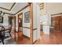 Elegant hallway leading to a kitchen and dining area with hardwood floors and decorative moldings at 2011 Sturbridge Ln, Buford, GA 30519