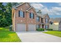 Charming two-story brick home with a well-manicured lawn and attached two-car garage in a suburban neighborhood at 2482 Brittany Park Ln, Ellenwood, GA 30294